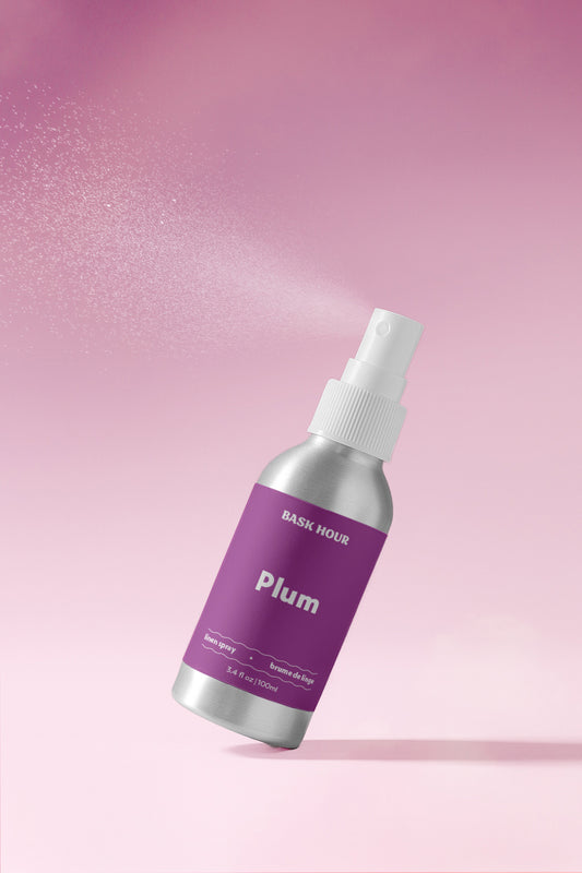 linen spray bottle labeled 'Plum' on a pink gradient background