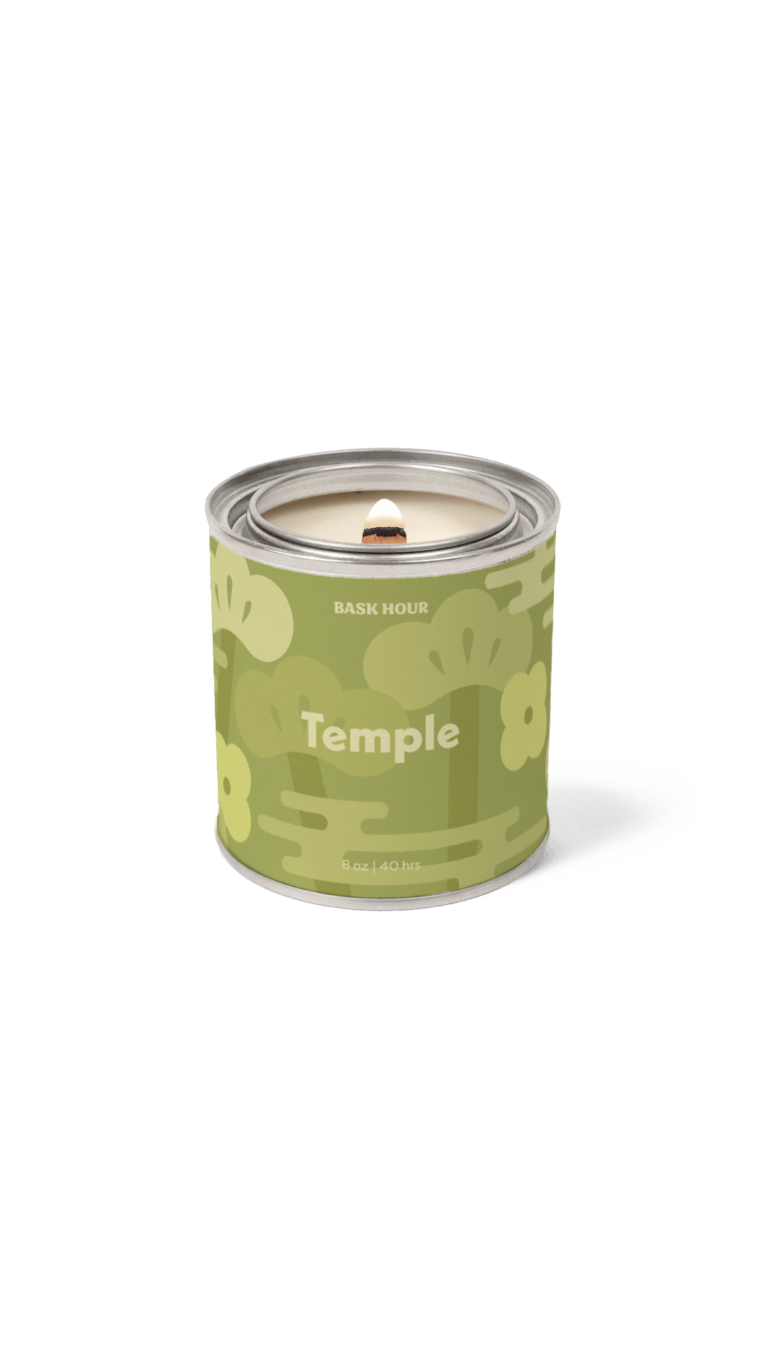A single lit candle in a cylindrical metal tin with a green floral label reading 'Temple' and 'BASK HOUR'. The candle is shown on a clean white background with a soft shadow.