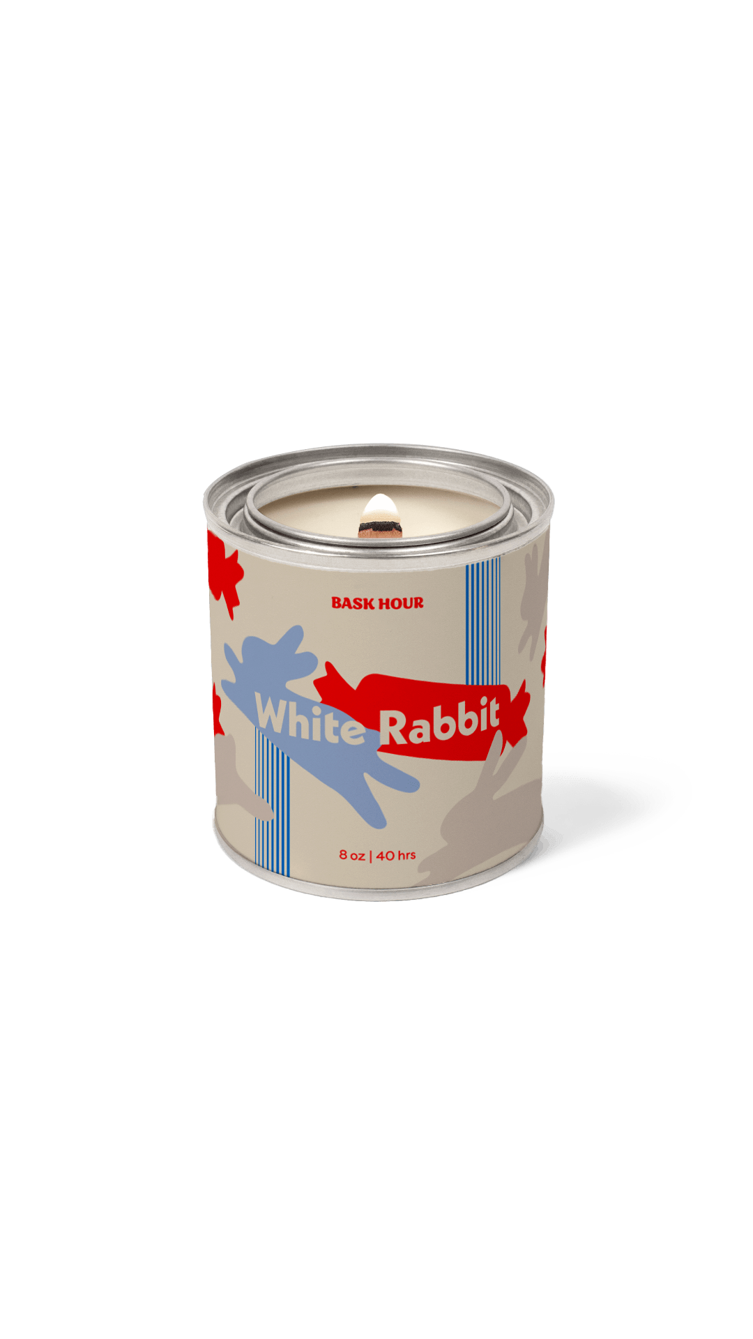 A single candle in a cylindrical tin with a lid, featuring a label that reads 'White Rabbit' and 'BASK HOUR.' The label has a beige base with a blue rabbit silhouette, red abstract shapes, and blue vertical stripes.